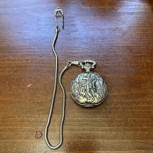 This silver-toned, embossed pocket watch features a classic "hunter and dogs"